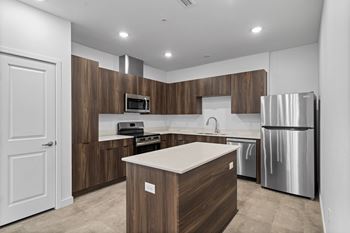 A modern kitchen with a wooden island and stainless steel appliances.